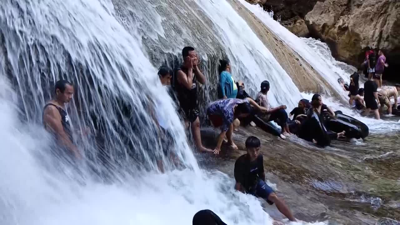 People Enjoying a Refreshing Waterfall