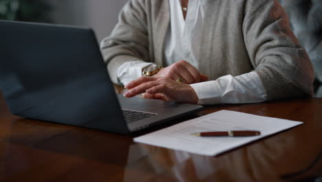 Mujer-De-Negocios-Senior-Usando-Una-Computadora-Portátil-En-El-Lugar-De-Trabajo-En-Casa.-Manos-De-Mujer-Mayor