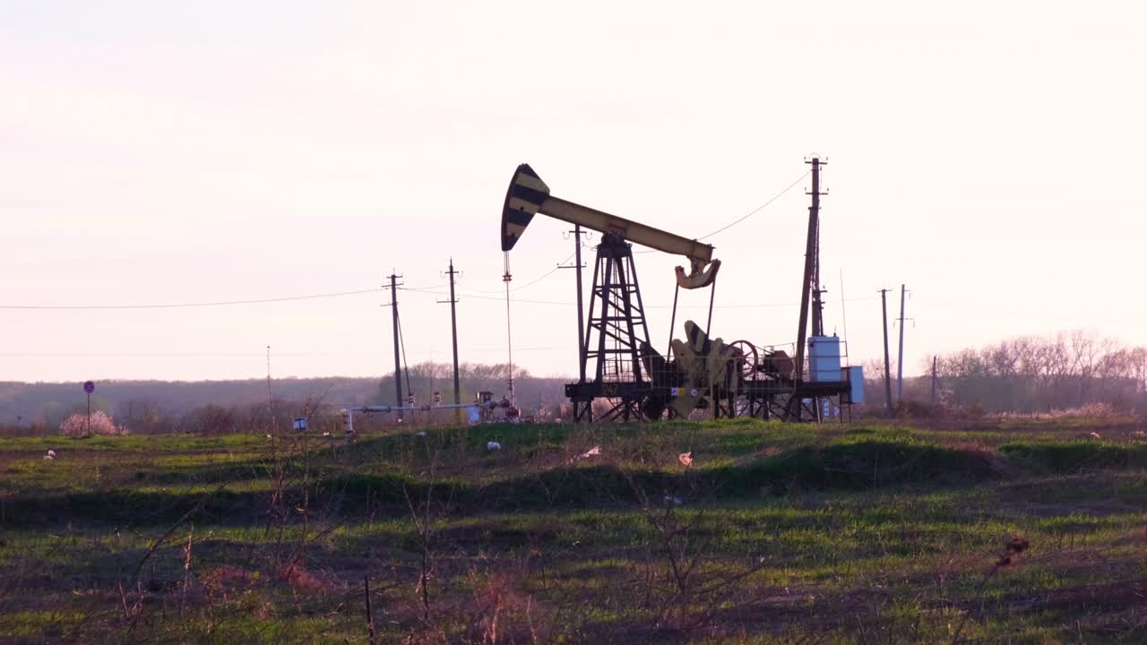 Industrial oil production industry, derrick pumps oil outdoors in the field on the oil platform. The concept of the economy, production and extraction of oil, environmental pollution, fuel, petroleum.