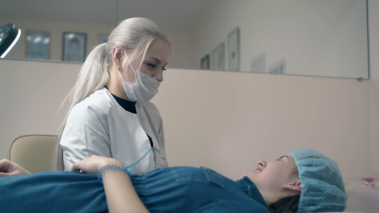 un cosmetologo spiega ai clienti i dettagli del tatuaggio della fronte