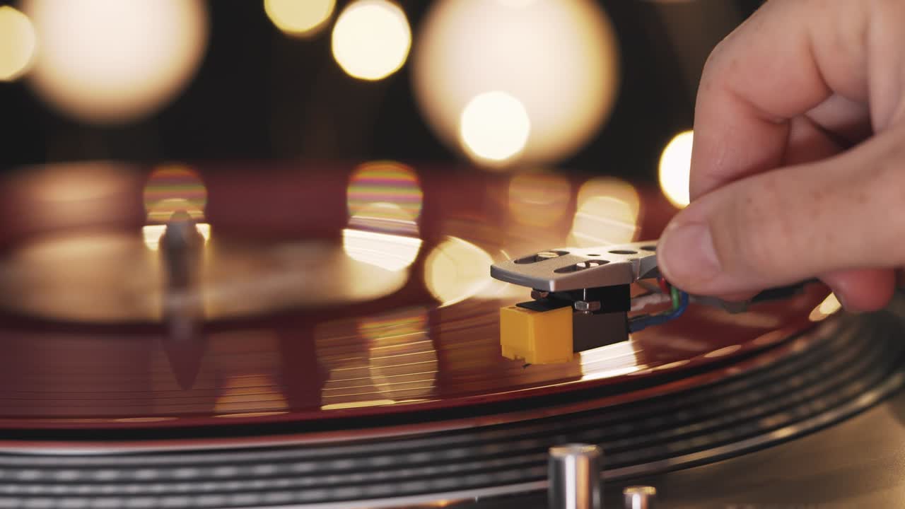 비닐 플레이어: 해가 지는 배경, 보케 조명, 저녁 도시, 소녀의 손이 바늘을 놓고 회전하는 빨간 비닐 판, 그라모폰 회전 판, 크리스마스 조명, 인기 있는 디스코 트렌드, 70년대, 80년대, 90년대