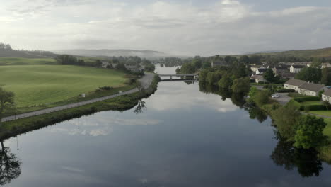 an aerial view of the river shin at lairg on a calm and misty summer's moring