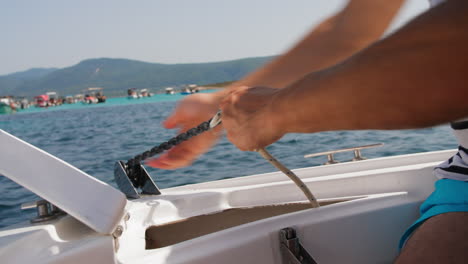 persona en un barco levantando el ancla en un mar tranquilo