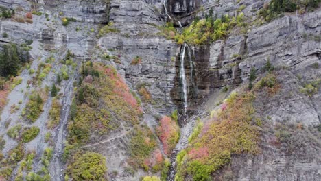 picturesque waterfall cascading in wasatch mountain cliffs - aerial