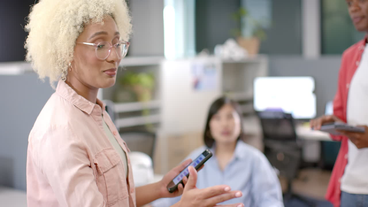 Discussing project, woman holding smartphone and gesturing in office meeting