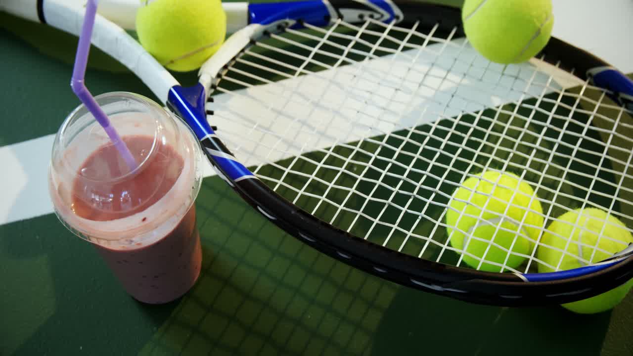 Milkshake and sports equipment in tennis court 4k