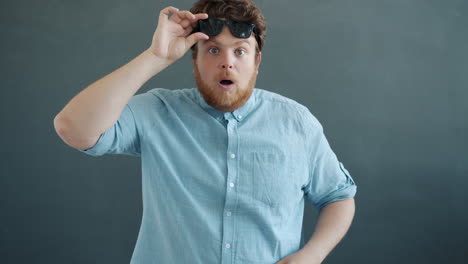 surprised man in blue shirt with sunglasses