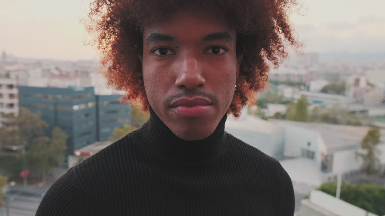 Portrait of a Smiling Man with Curly Hair in the City