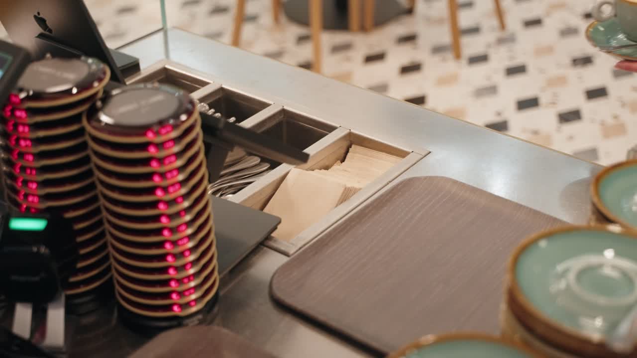Un barista che posa il caffè pronto su un piattino e un cliente lo prende.