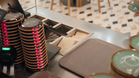 a barista putting the finished coffee on a plate and a customer takes it