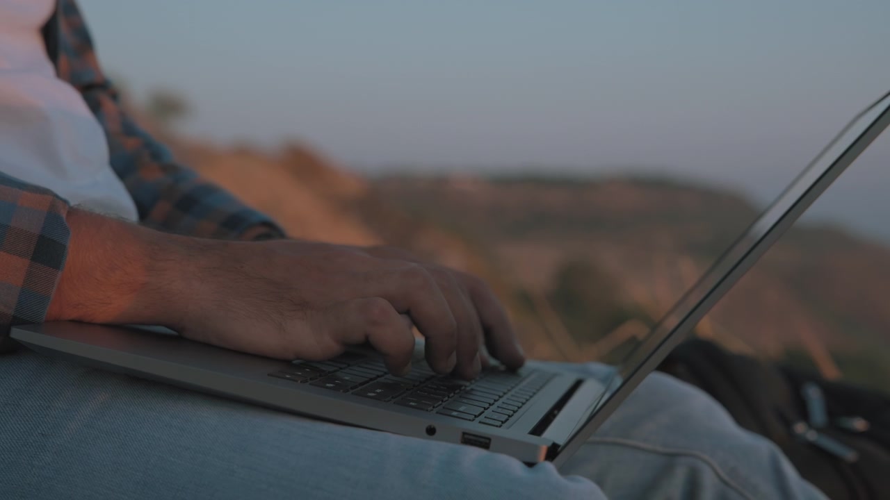 A man's hands typing on laptop