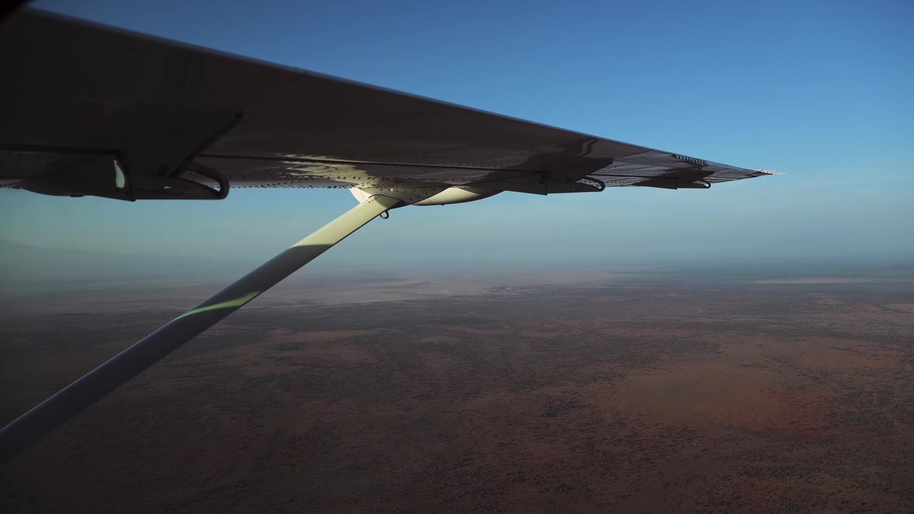 Vista Aérea de Amboseli de Avião de Safári no Quênia. Cenário Africano de Avião, Voando Sobre Paisagem Seca, Árida, de Estação Seca na África em um Pequeno Avião