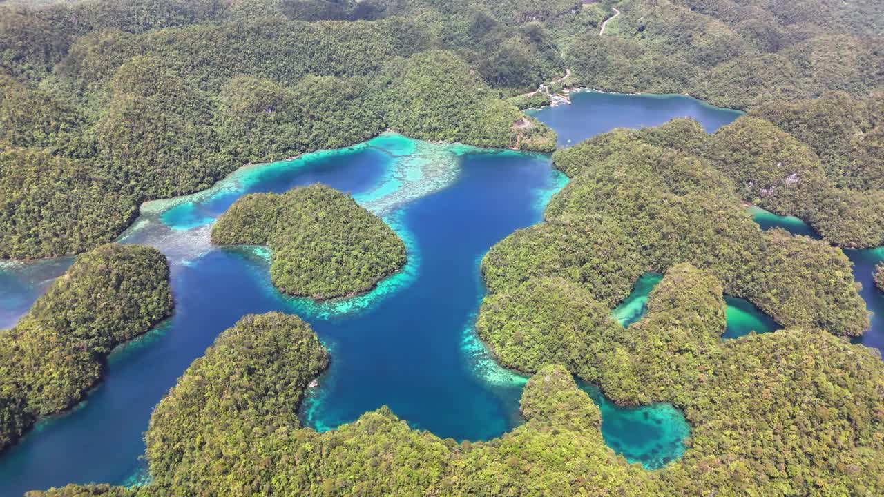 Stunning aerial shot of Sohoton Cove in Siargao, Philippines, shows winding turquoise lagoons surrounded by green islets, dense tropical forest, and crystal-clear water, highlightingl Bucas Grande