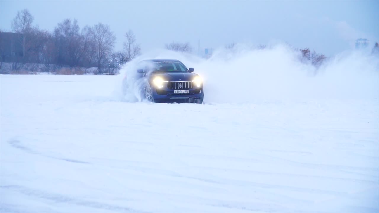 maserati suv a la deriva en el hielo cubierto de nieve