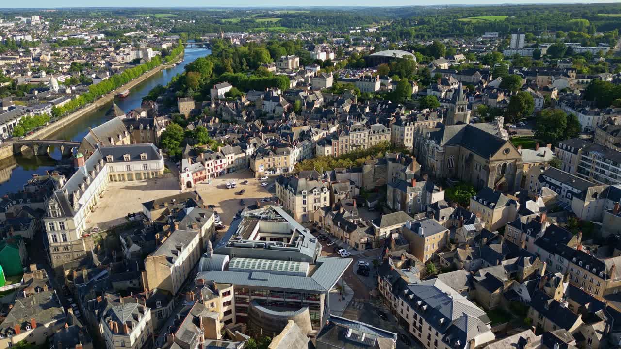 Slow Aerial view over Laval city centre, with Château de Laval and Château Neuf beside the Mayenne River, Cathédrale de la Sainte Trinité visible in old town expanding to Pays de la Loire landscape