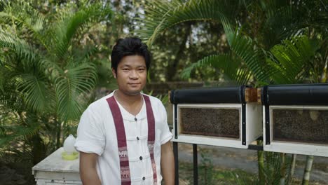 man inspecting beehives