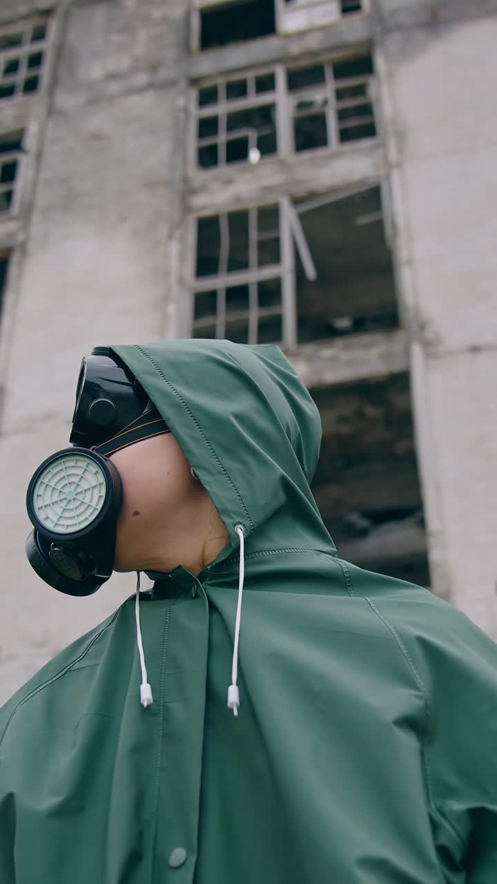 Human in radioactive hazmat standing in apocalypsis city. Protective ecology in radioactive mask. Vertical video