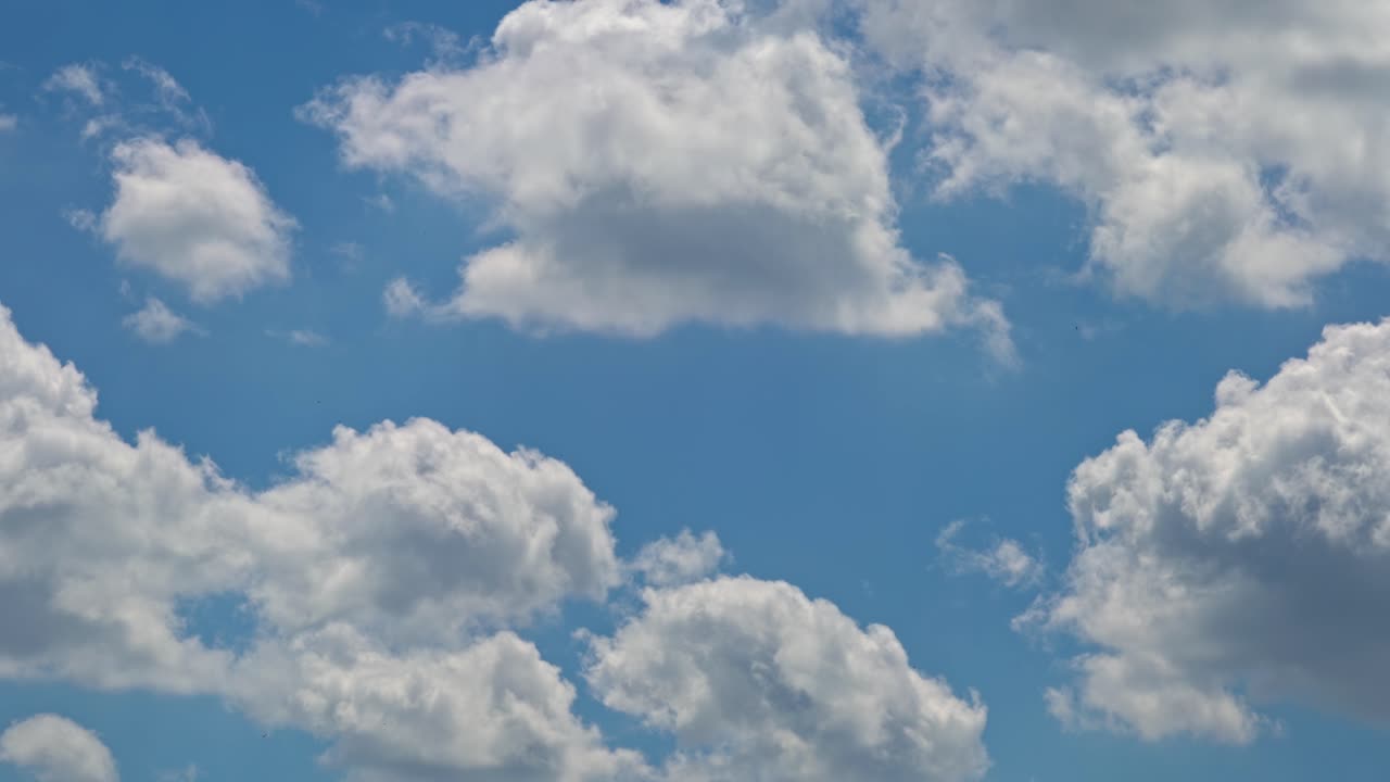 Clouds float in a blue sky on a sunny day in the afternoon
