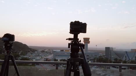 panning from left to right capturing two cameras capturing curacao international airport when dusk is near