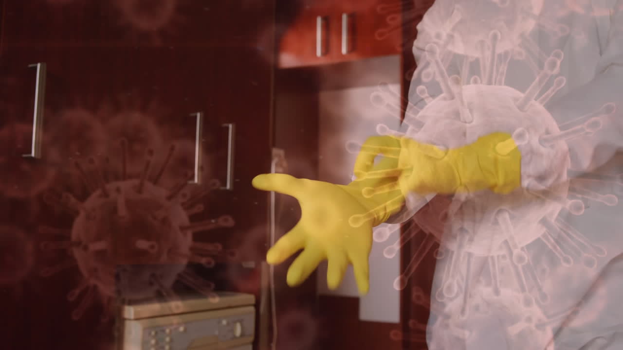 células de covid-19 que se extienden sobre un hombre que usa un traje de protección que se pone una máscara facial en el fondo