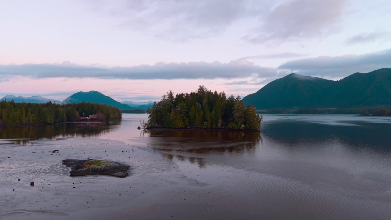 Drone shot of Tofino on Vancouver Island displaying autumn colors, rugged coastline, and ocean waves in a scenic aerial view.