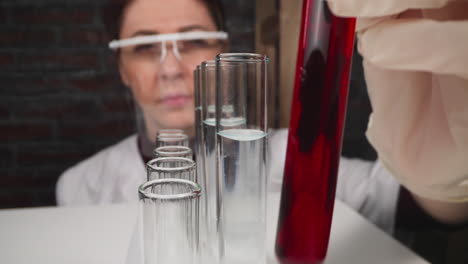 doctor with face shield takes test tube to check sample