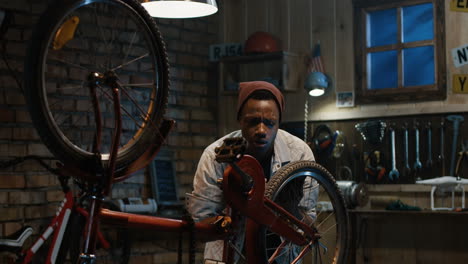 man repairing a bicycle in a garage