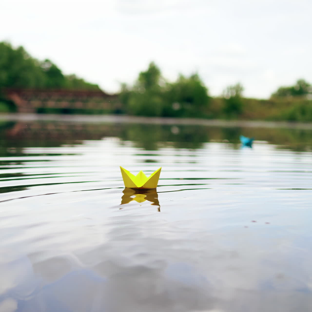 A paper ship floating in the river on the waves. Origami Paper Boat