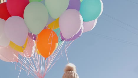 woman holding bunch of balloons