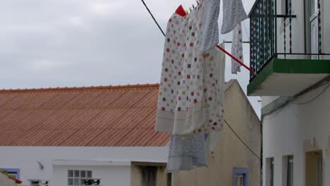 Laundry-hanging-to-dry-in-an-alleyway-in-the-town-of-Nazare,-Portugal_01