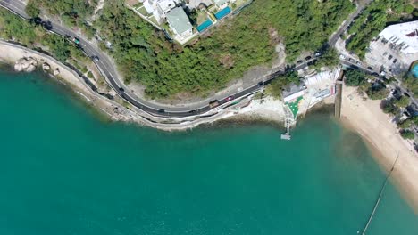 carretera costera de la bahía de hong kong con tráfico y tranquilas aguas turquesas, vista aérea