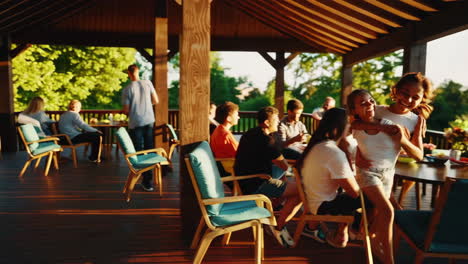 a vibrant outdoor gathering of friends and family, with a young woman laughing joyfully under the warm sun