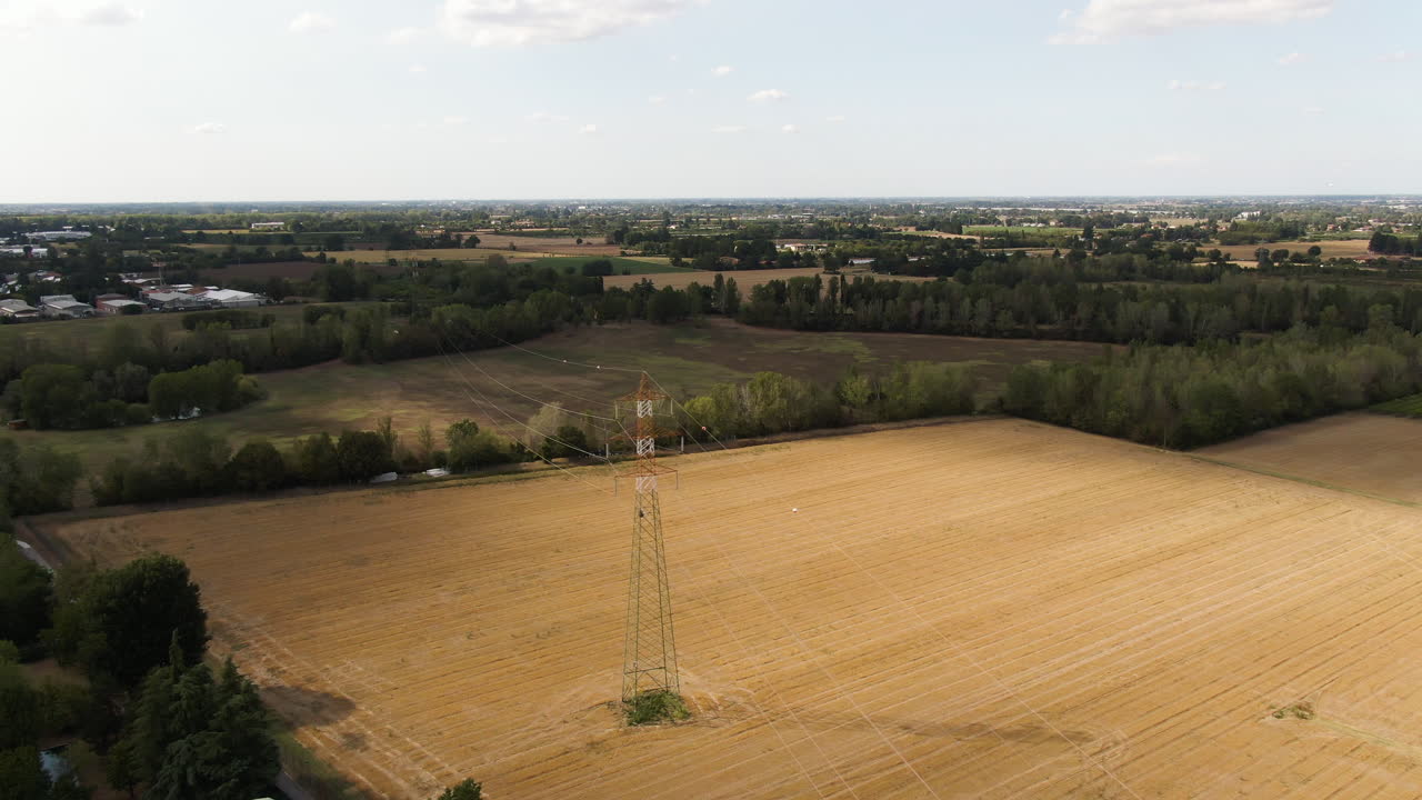 Electric pole of high voltage air cable line in agriculture fields, aerial drone view