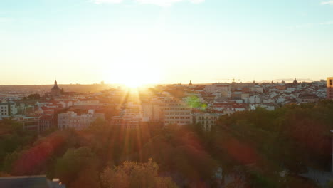 Forwards-ascending-fly-along-historic-palace.-Revealing-of-cityscape-against-setting-sun.