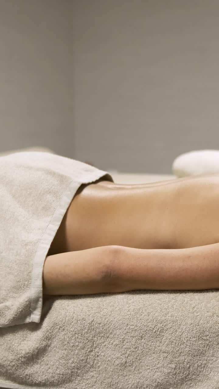 Woman enjoying a relaxing moment on a massage table. Vertical