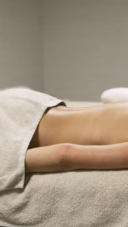woman enjoying a relaxing moment on a massage table. vertical