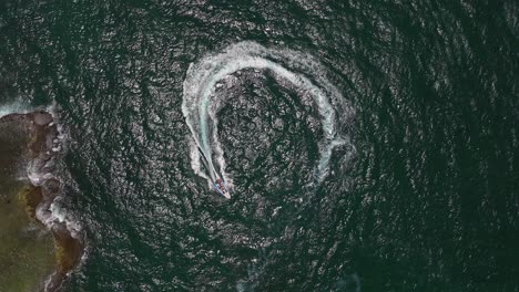 extreme jet boat roaring across the sea with tourists, aerial footage