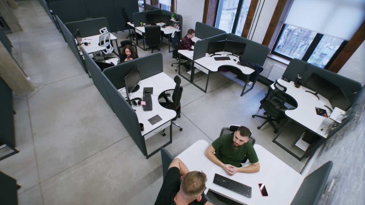 High-angle view of a modern open-plan office with employees working at their desks