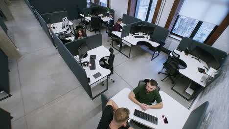 high-angle view of a modern open-plan office with employees working at their desks
