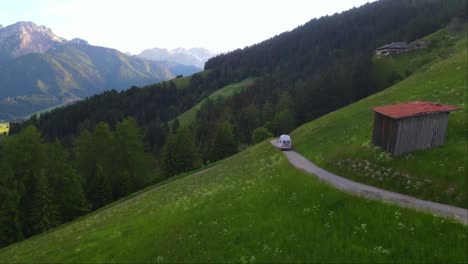 Drohne-Folgt-Einem-Weißen-Wohnmobil-Durch-Eine-Kurvenreiche-Bergstraße-Rund-Um-Die-Alpen---Drohnenaufnahme