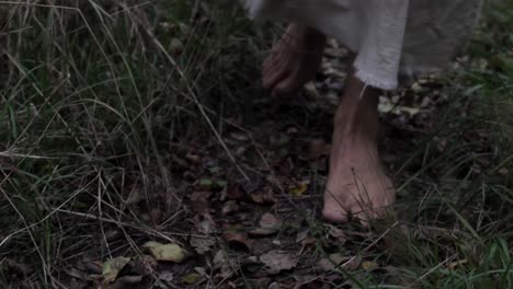 primer plano de los pies del hombre vestido o de jesús caminando a través de los árboles del bosque en cámara lenta