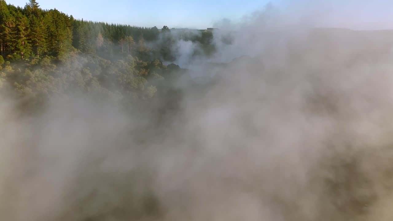 Golden sunrise, Drone slowly flying over geothermal landscape. Trees, steam, bubbling mud and steam. Alien Landscape. Sci-fi. Global Warming