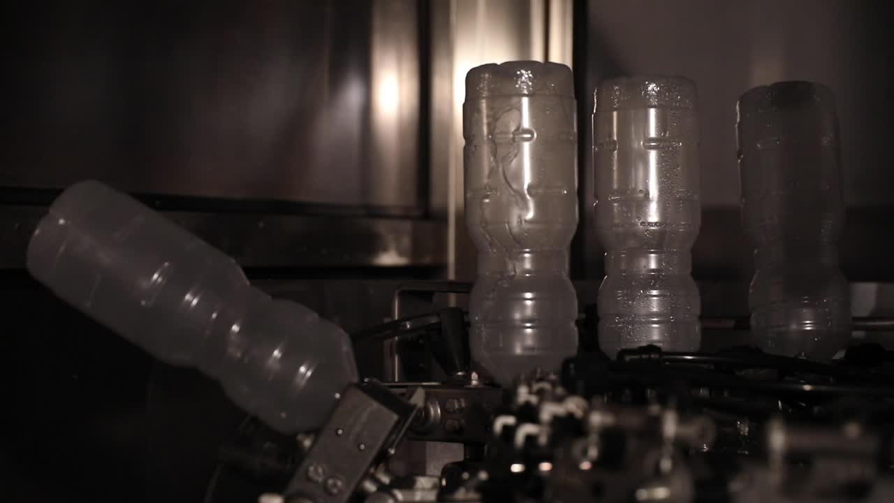 Upside Down Plastic Bottles Being Sterilized and Washed Before Being Filled with Vinegar at a Factory