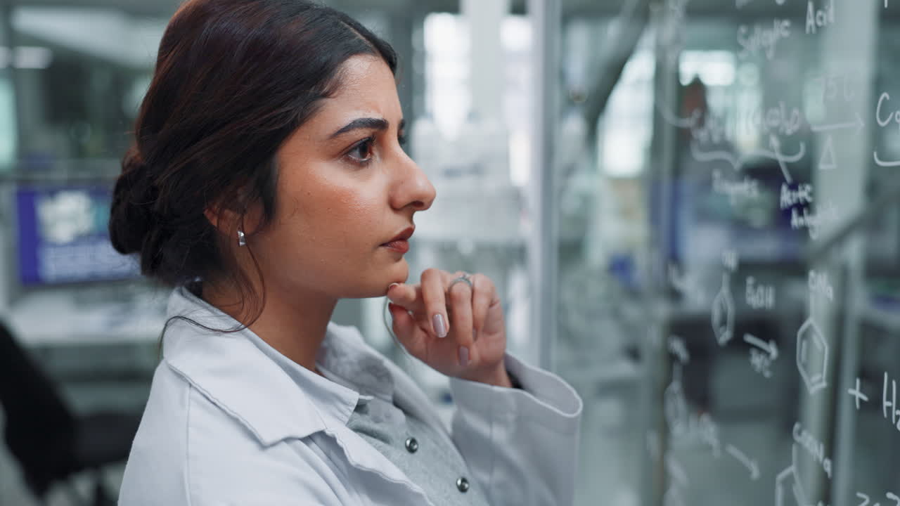 Scientist analyzing chemical formulas in a lab