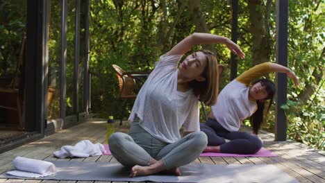 madre y hija asiáticas practicando yoga al aire libre en el jardín