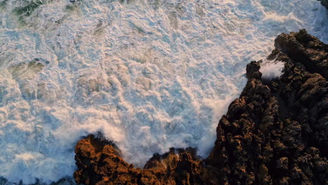 aerial view stormy ocean waves breaking volcanic rocks. water stream landscape