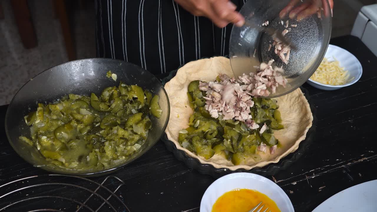 panadera mezclando rodajas de calabacín y carne en una base de pastel
