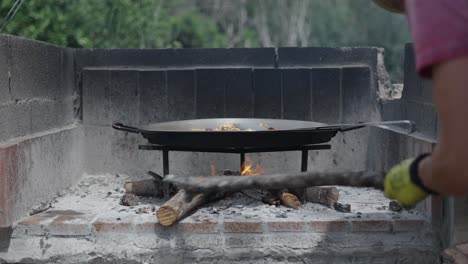outdoor cooking over wood fire in a large pan
