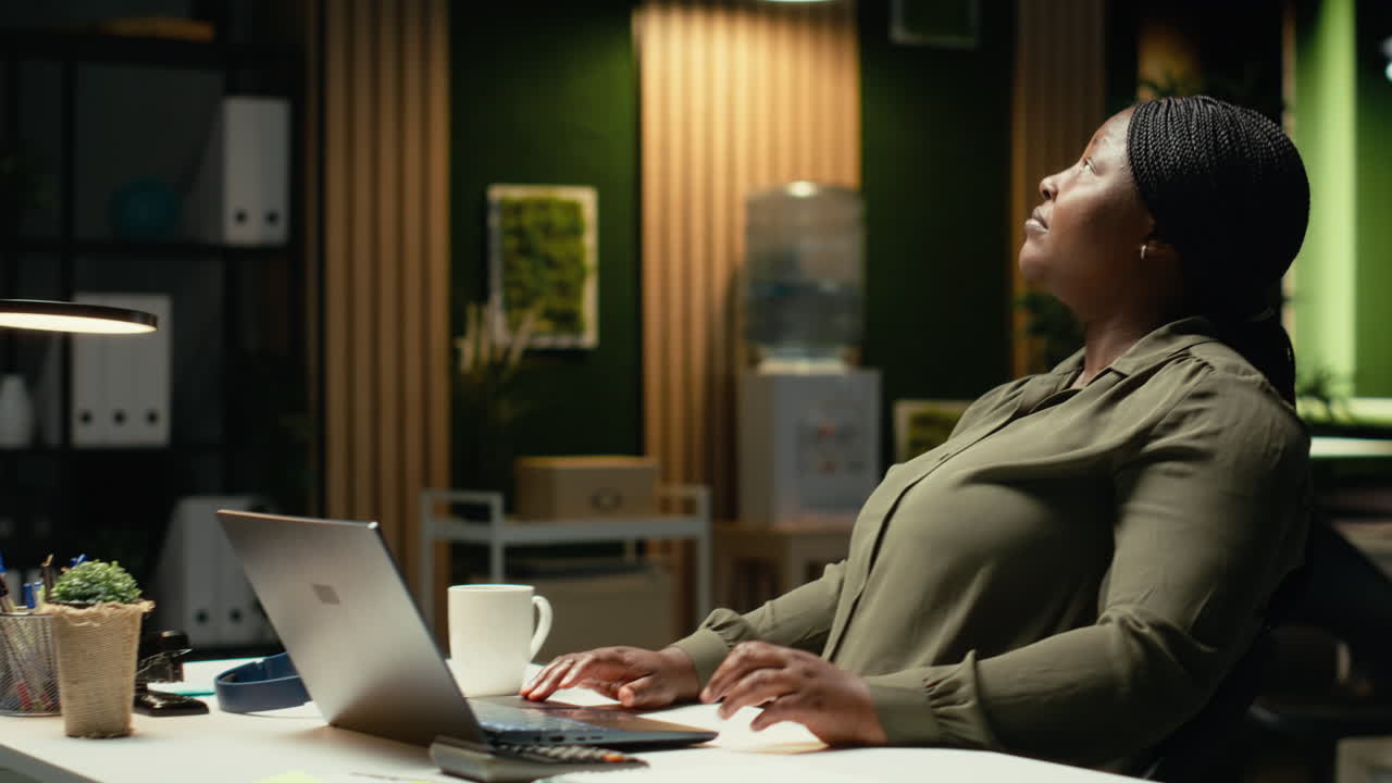 Black consultant focusing on a complex problem in a dark office at midnight