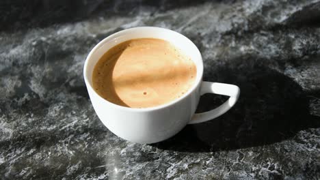 white coffee filled cup on black marbled table